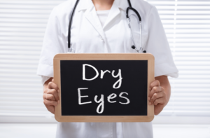 An optometrist holding a sign that says "dry eyes"