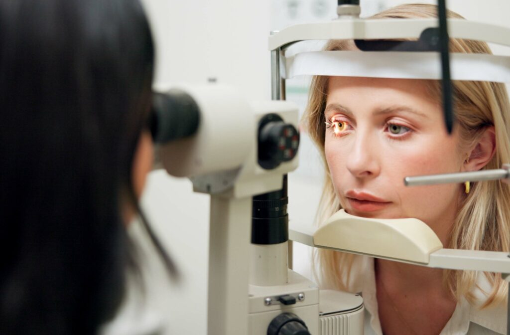 Optometrist performs a detailed eye exam and contact lens evaluation on a patient using modern diagnostic equipment.