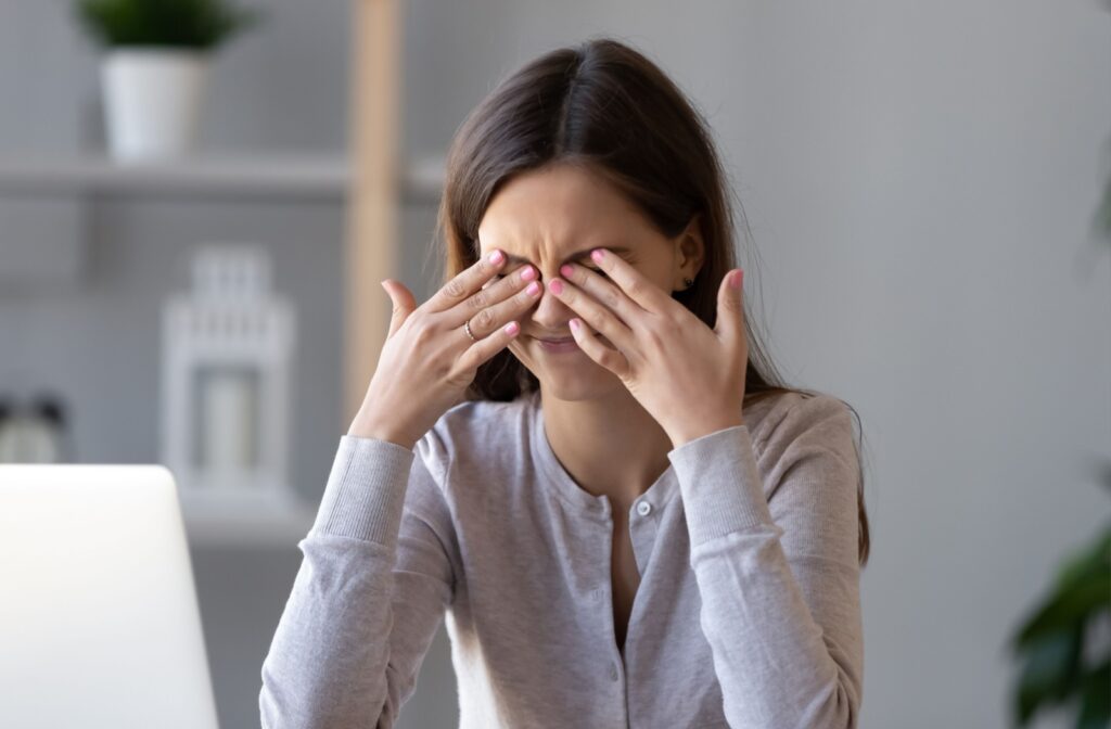 A girl rubs at her dry eyes.