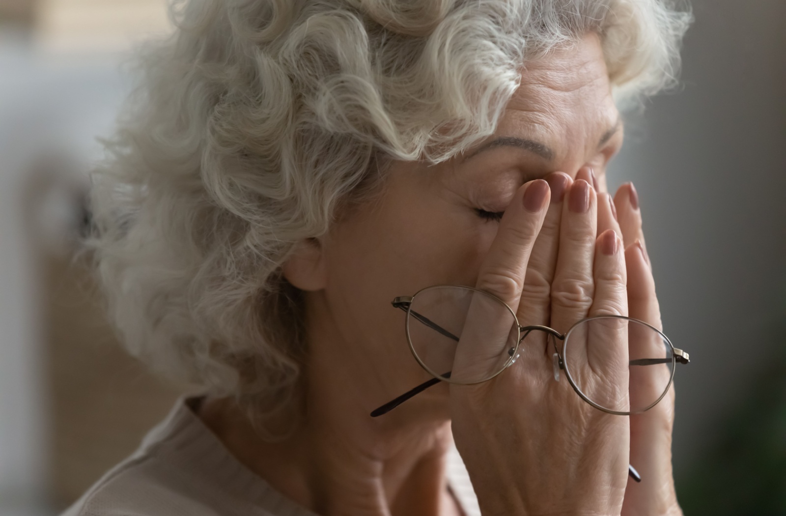A person takes their glasses off and rubs their eyes to find temporary dry eye relief.
